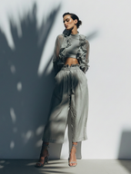 Completo composto da crop top trasparente con volant e pantaloni a gamba larga in misto seta grigio chiaro.