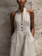 Vestido midi de lino con cuello halter, botones en la parte delantera y cinturón ancho en la cintura.