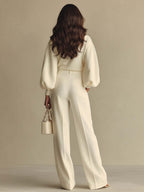 Completo composto da maglione a maniche larghe color crema in maglia morbida e pantaloni a vita alta con pieghe.