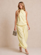 Completo composto da top all'americana e pantaloni a gamba larga in misto lino color giallo chiaro.