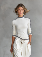 Conjunto de top blanco de manga larga y cuello alto con rayas laterales y pantalón ancho a juego, confeccionado en mezcla de algodón.